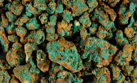 Accumuli di malachite aderenti alla superficie di piccole pietre e grumi di idrossido ferroso.